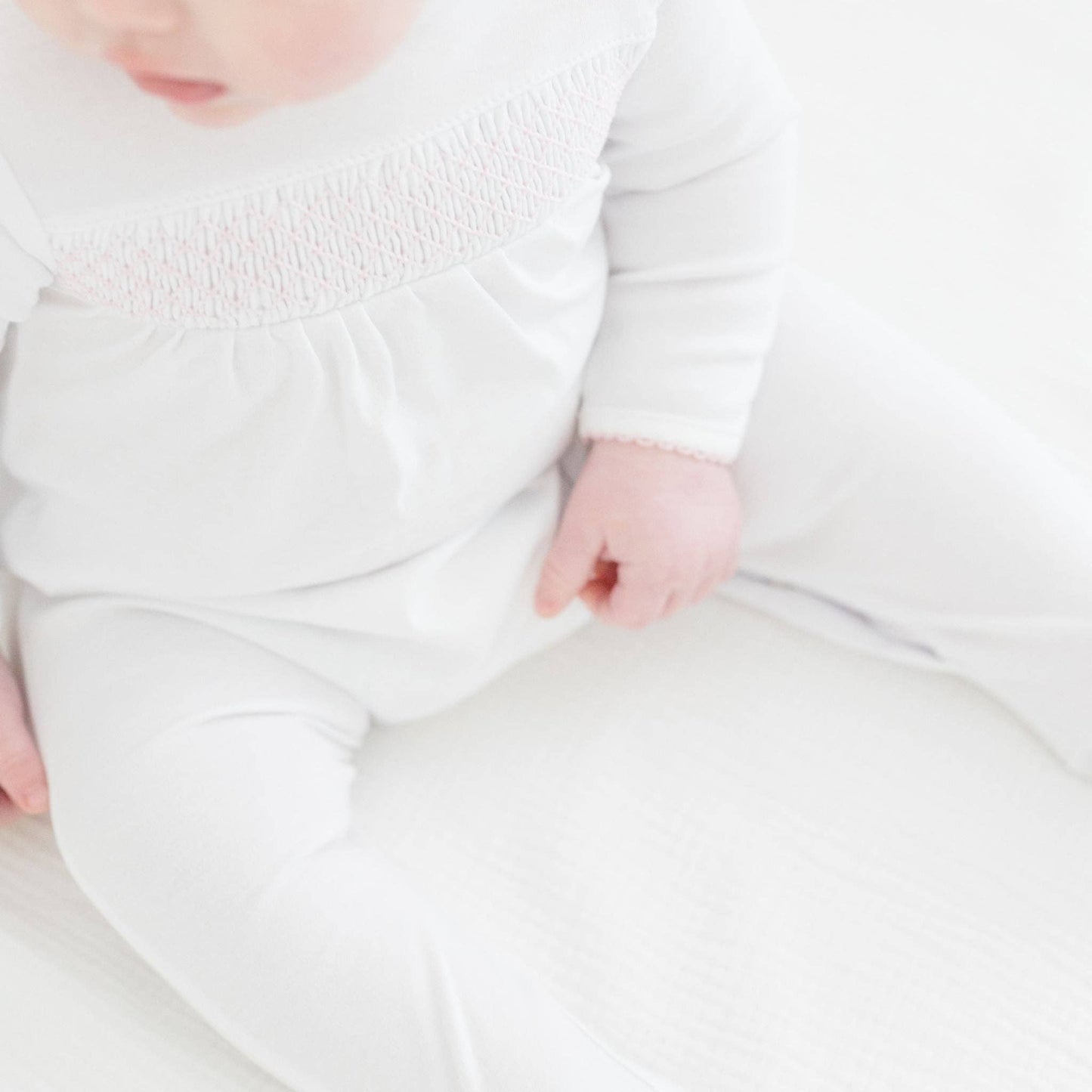White Smocked Footie – Pink Trim