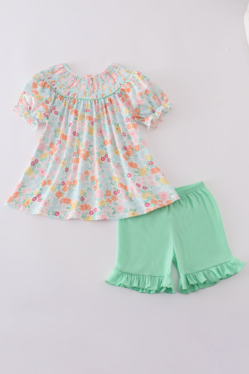 Smocked top with spring flowers and green ruffled shorts
