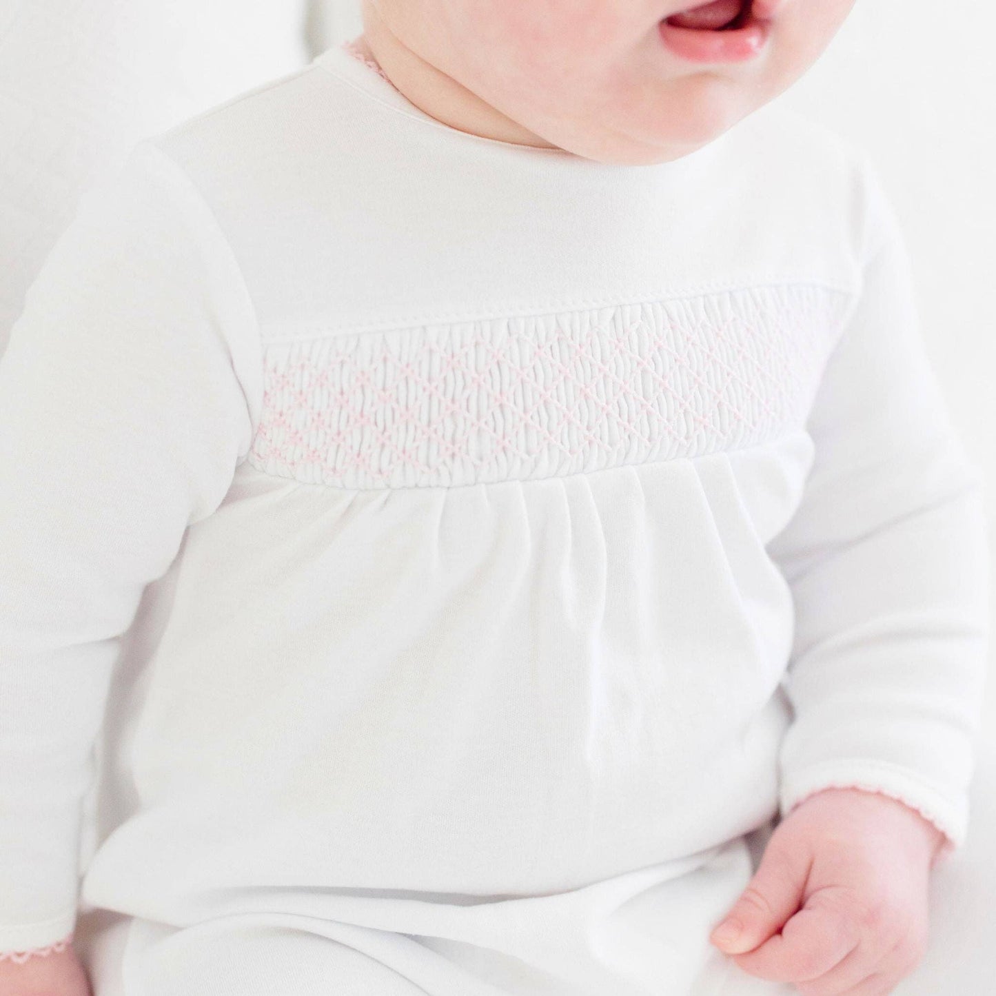 White Smocked Footie – Pink Trim